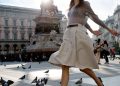 woman crossing the street among pigeons