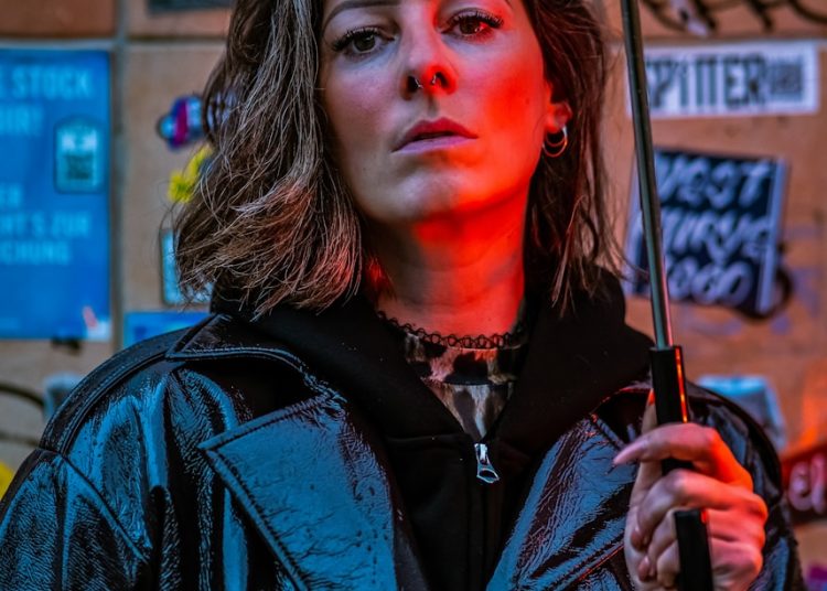 Woman holding umbrella in neon city lights
