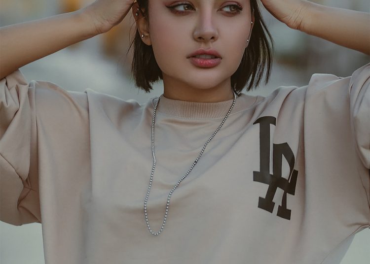 a young woman is holding her hands to her head
