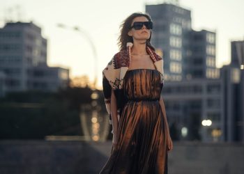 woman in brown dress standing near body of water during daytime
