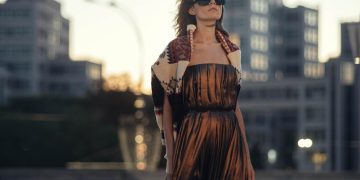 woman in brown dress standing near body of water during daytime