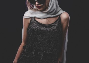 woman in black sleeveless dress wearing black sunglasses