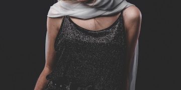 woman in black sleeveless dress wearing black sunglasses