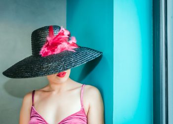 woman wearing pink camitop and black straw hat