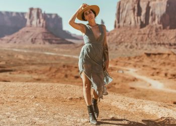 woman in grey dress standing on brown sand during daytime