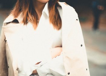 a woman wearing a trench coat and a hat
