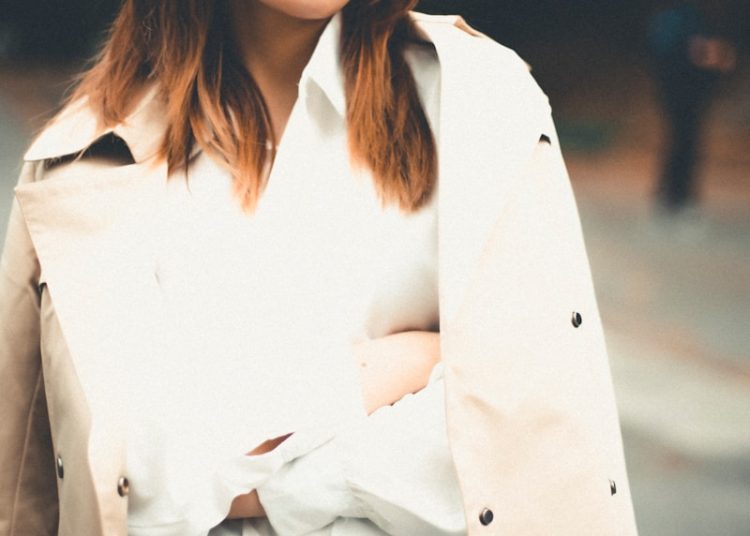a woman wearing a trench coat and a hat