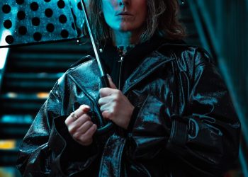 Woman holding polka dot umbrella in blue light