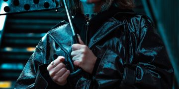 Woman holding polka dot umbrella in blue light