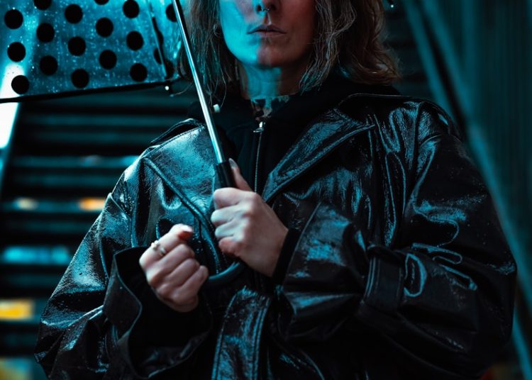 Woman holding polka dot umbrella in blue light