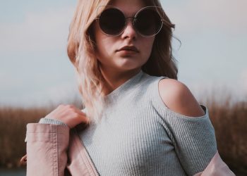 A woman wearing sunglasses and a pink jacket