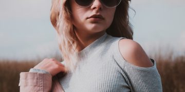 A woman wearing sunglasses and a pink jacket