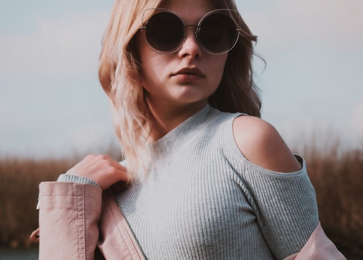A woman wearing sunglasses and a pink jacket