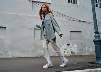 a woman with red hair walking down the street