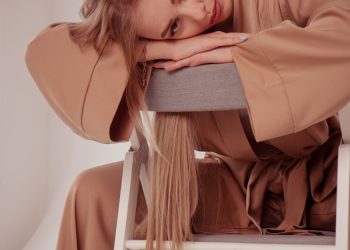 a woman sitting on a chair with her head on her hand