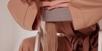 a woman sitting on a chair with her head on her hand