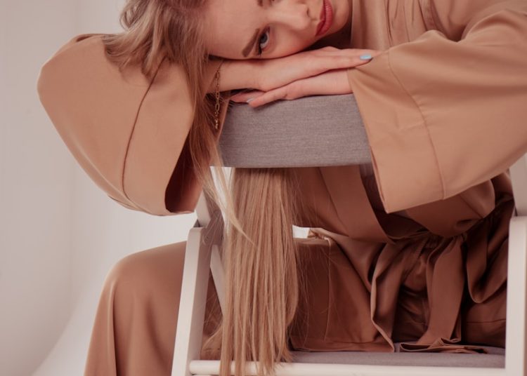 a woman sitting on a chair with her head on her hand